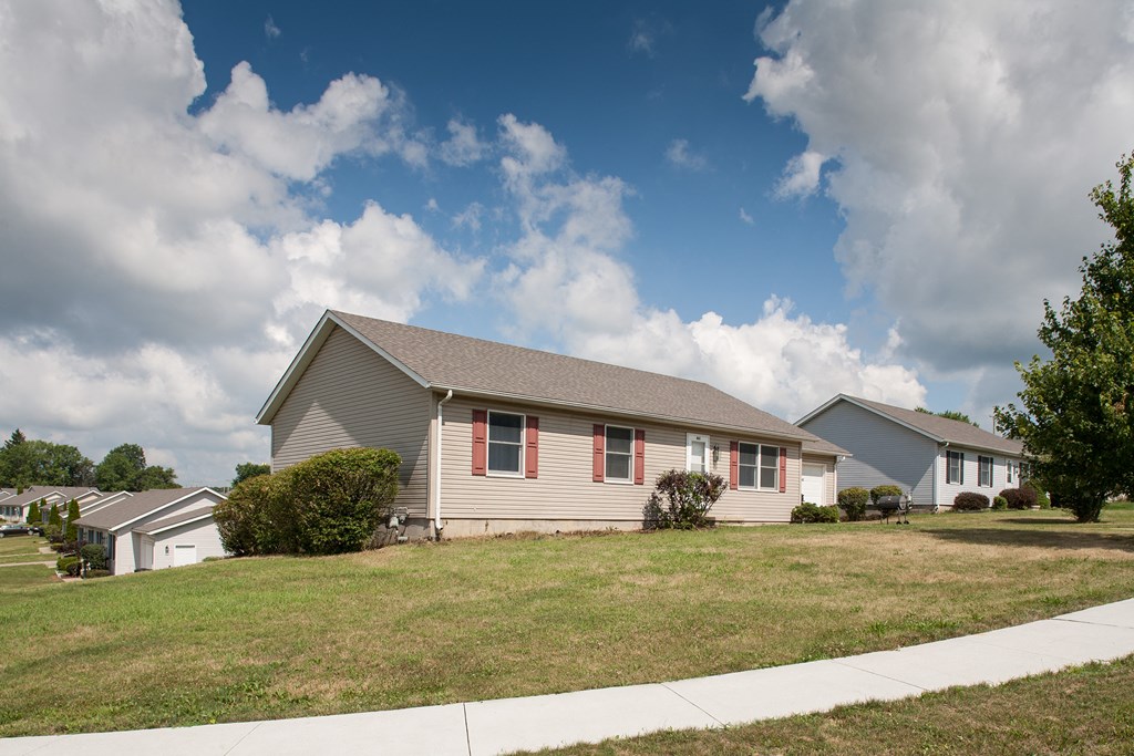 a house with a lawn in front of a sidewalk