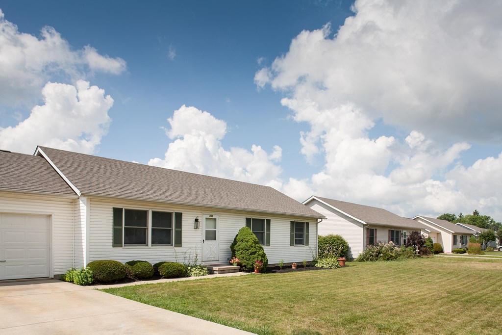 a white house with a lawn and a blue sky