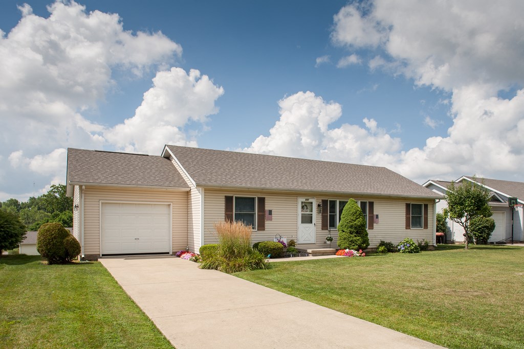a white house with a lawn and a driveway