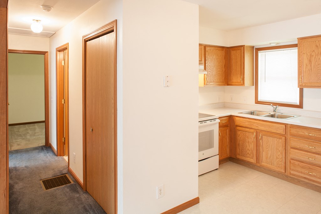 a kitchen with wooden cabinets and a stove and a sink