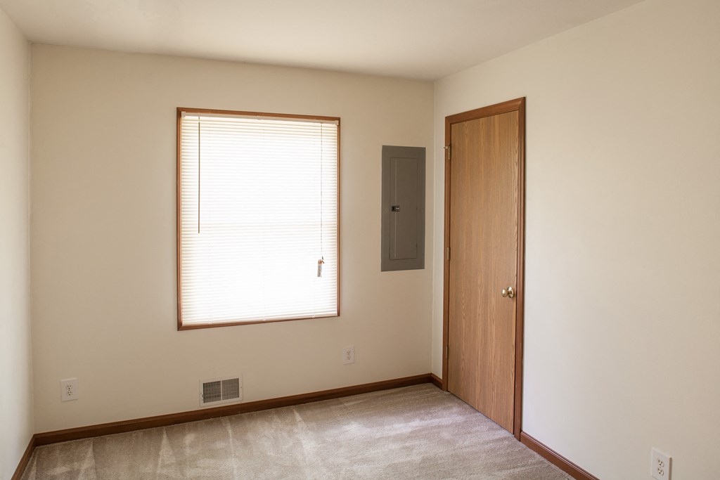 an empty room with a window and a door