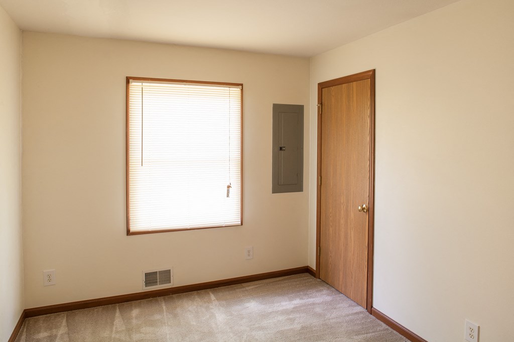 an empty room with a window and a door