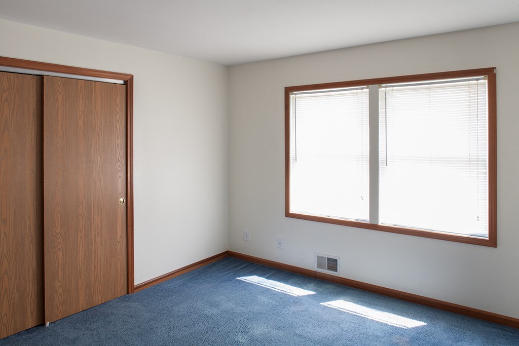 an empty room with a window and a door