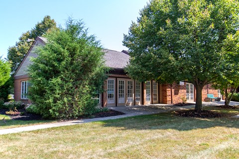 a red brick house with two trees in front of it