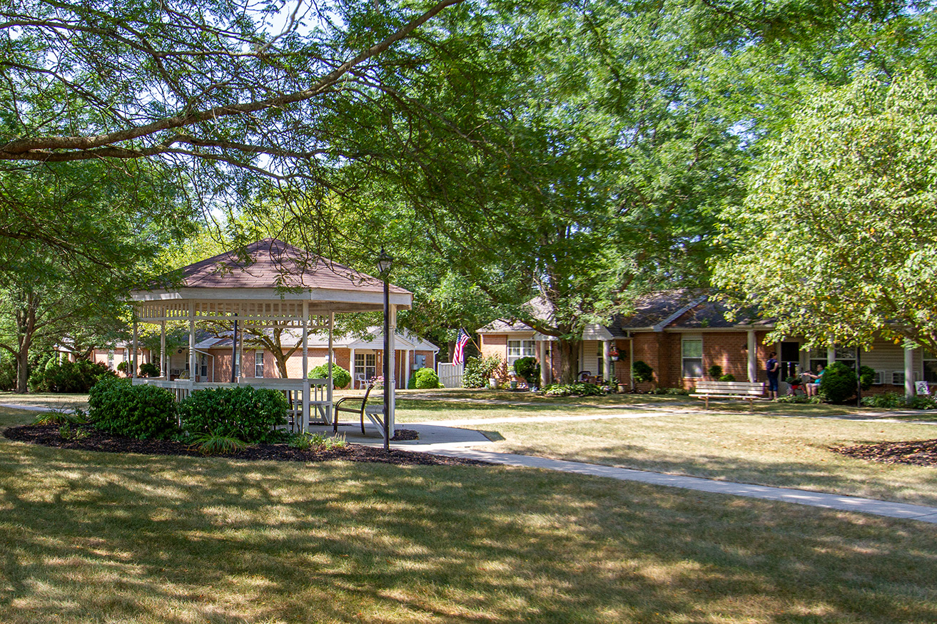 a park with a gazebo in front of some houses