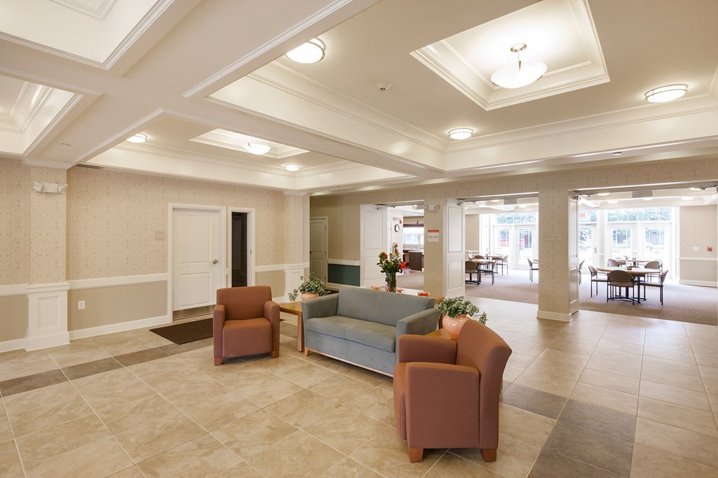 a lobby with couches and chairs and a table in the background