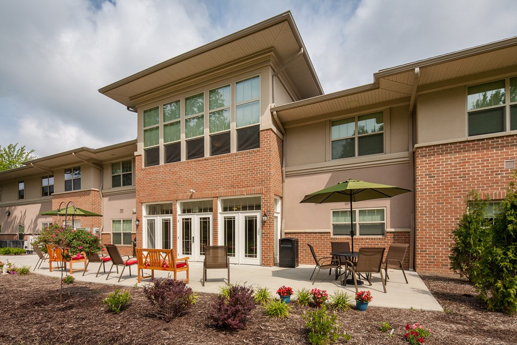 a patio with chairs and an umbrella outside of a building
