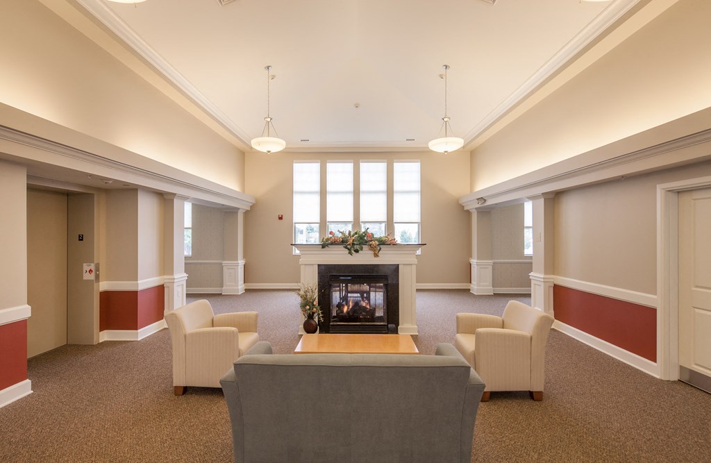 a large living room with a fireplace and chairs
