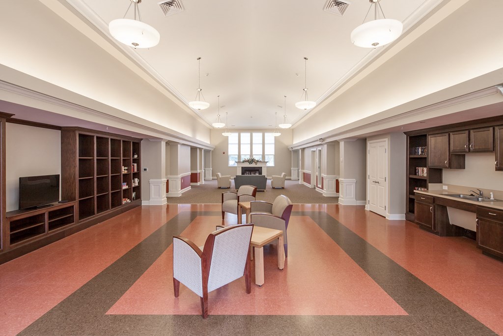 a large room with chairs and tables and a counter in the middle