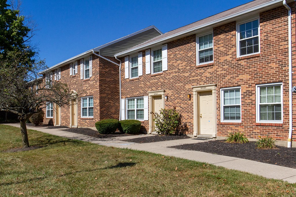 a brick building with a white door and a sidewalk