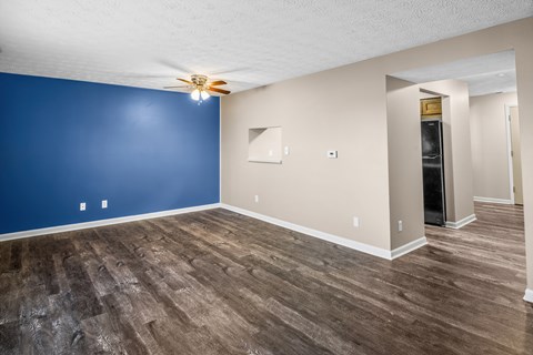a living room with blue and white walls and a ceiling fan