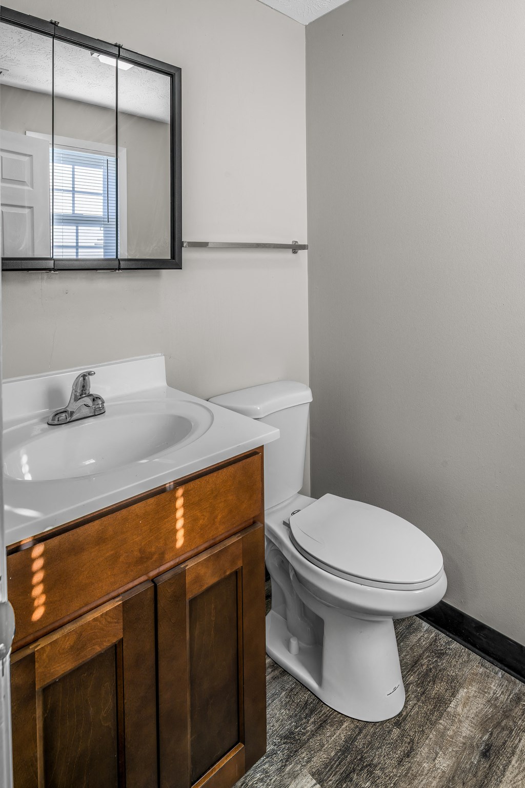 an empty bathroom with a toilet sink and mirror