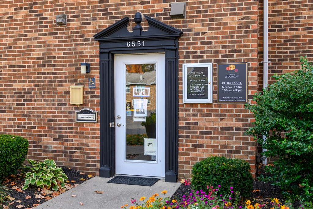 a brick building with a black door and a glass window