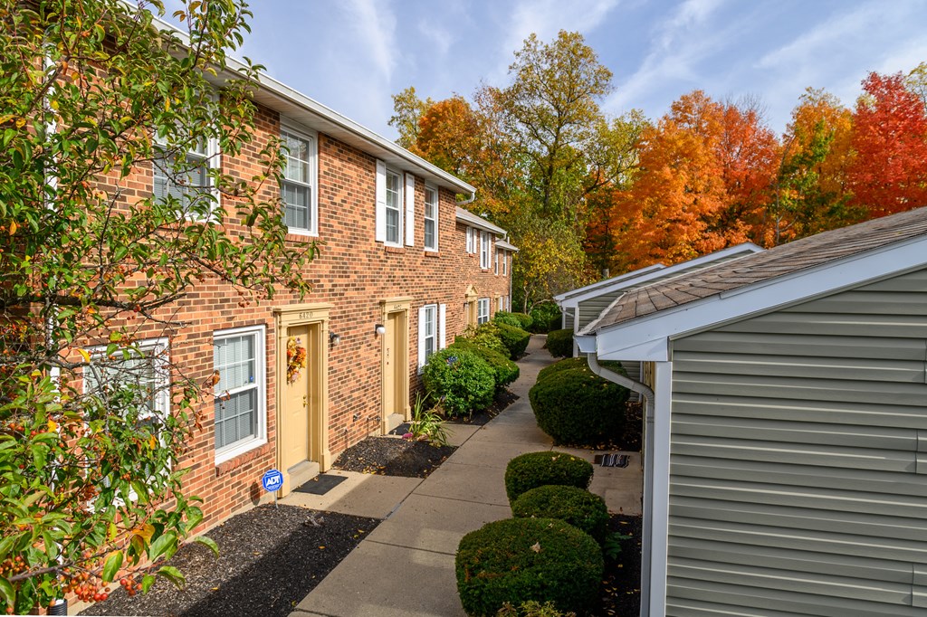 exterior view of a brick apartment building with a sidewalk