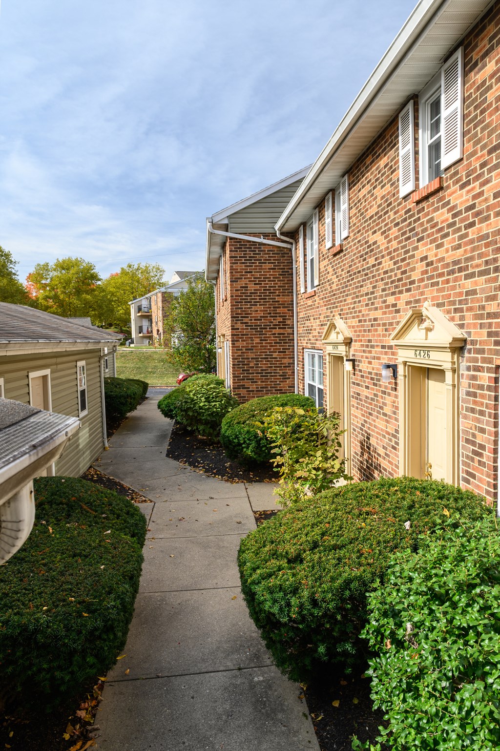 a sidewalk in front of a brick apartment building