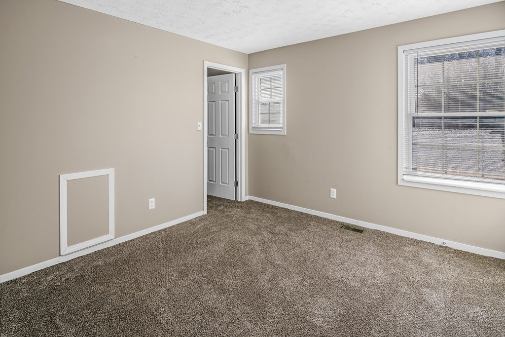 an empty room with carpet and a door