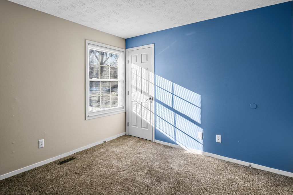 an empty room with blue walls and a white door