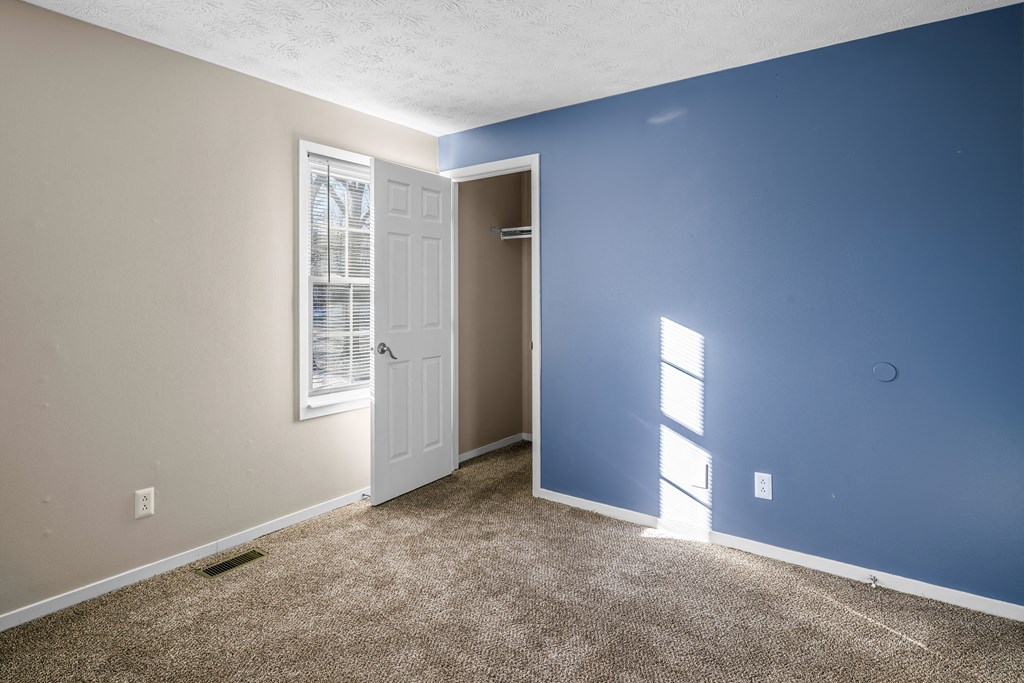 an empty room with blue and white walls and a white door
