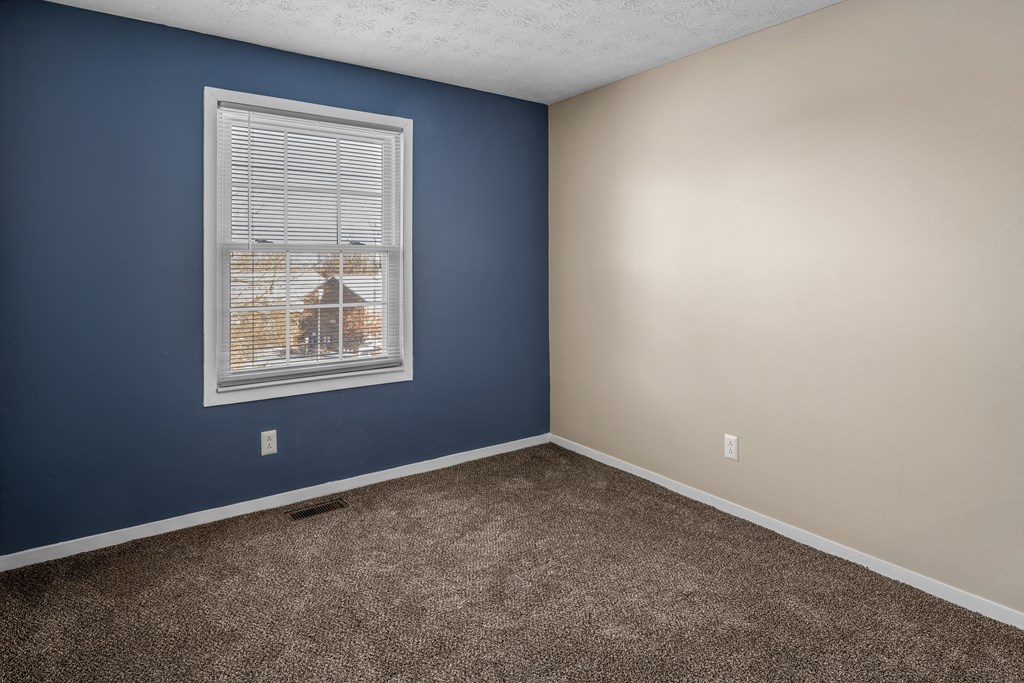 an empty room with carpet and a window