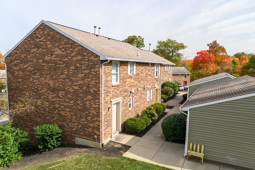 a small brick house with a yard and a sidewalk