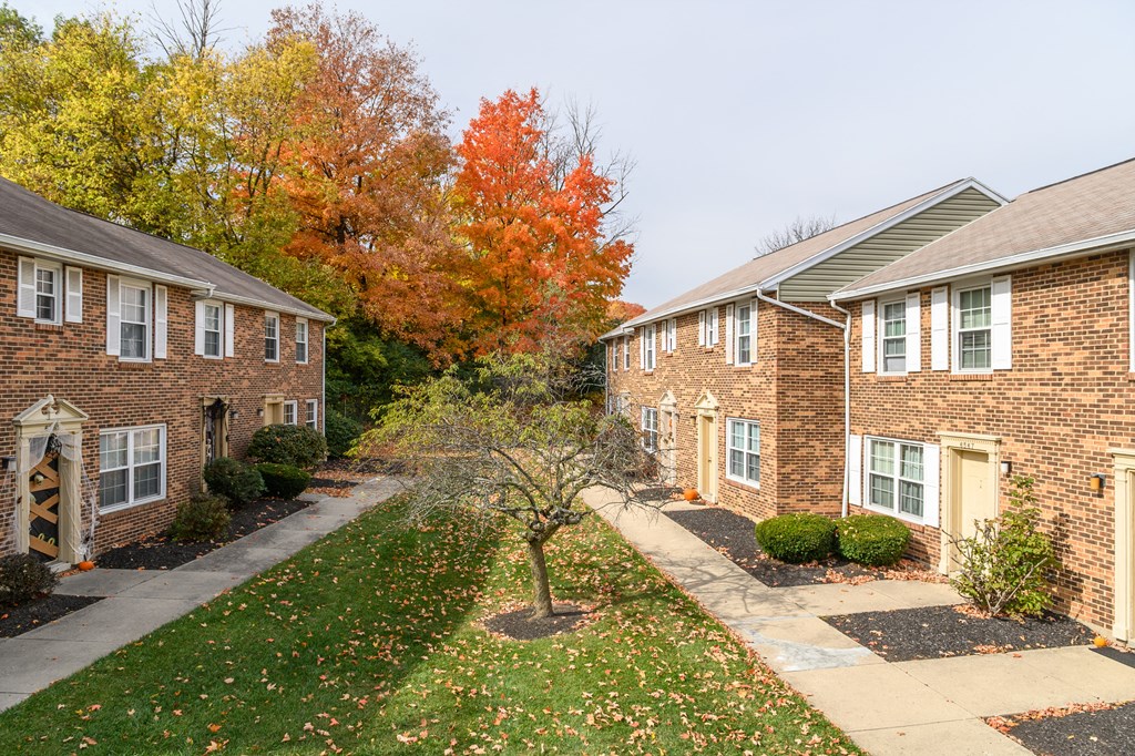 a sidewalk in front of a brick house