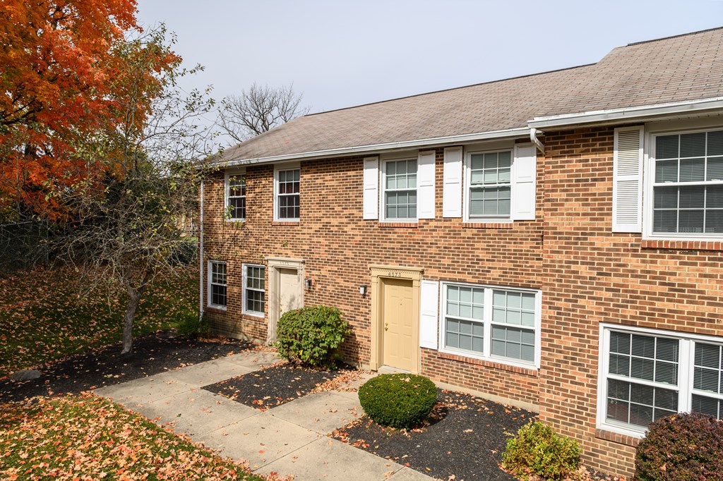 the front of a brick house with a yellow door