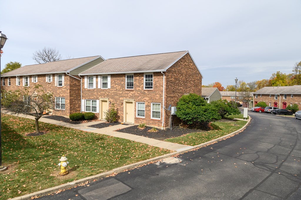 a large brick house with a street in front of it