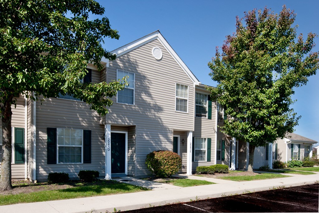 a gray house with trees in front of it