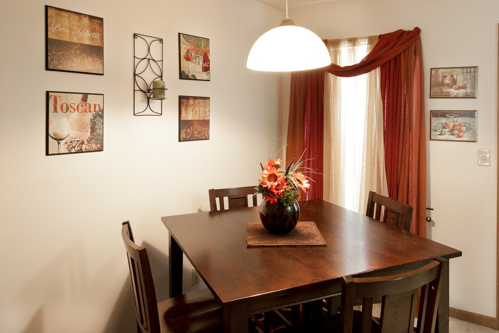 a dining room table with a vase of flowers on it