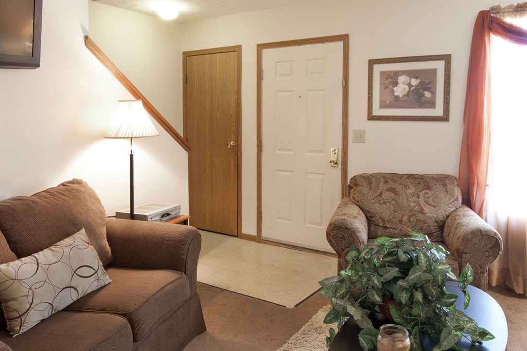 a living room with two couches and a table with a plant