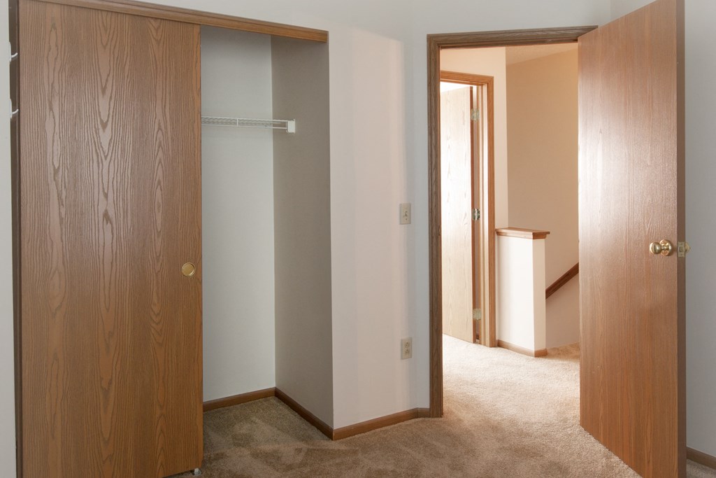 a bedroom with a closet and a door to a bathroom