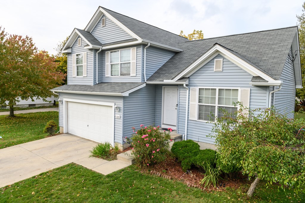 a blue house with a driveway and a white garage door