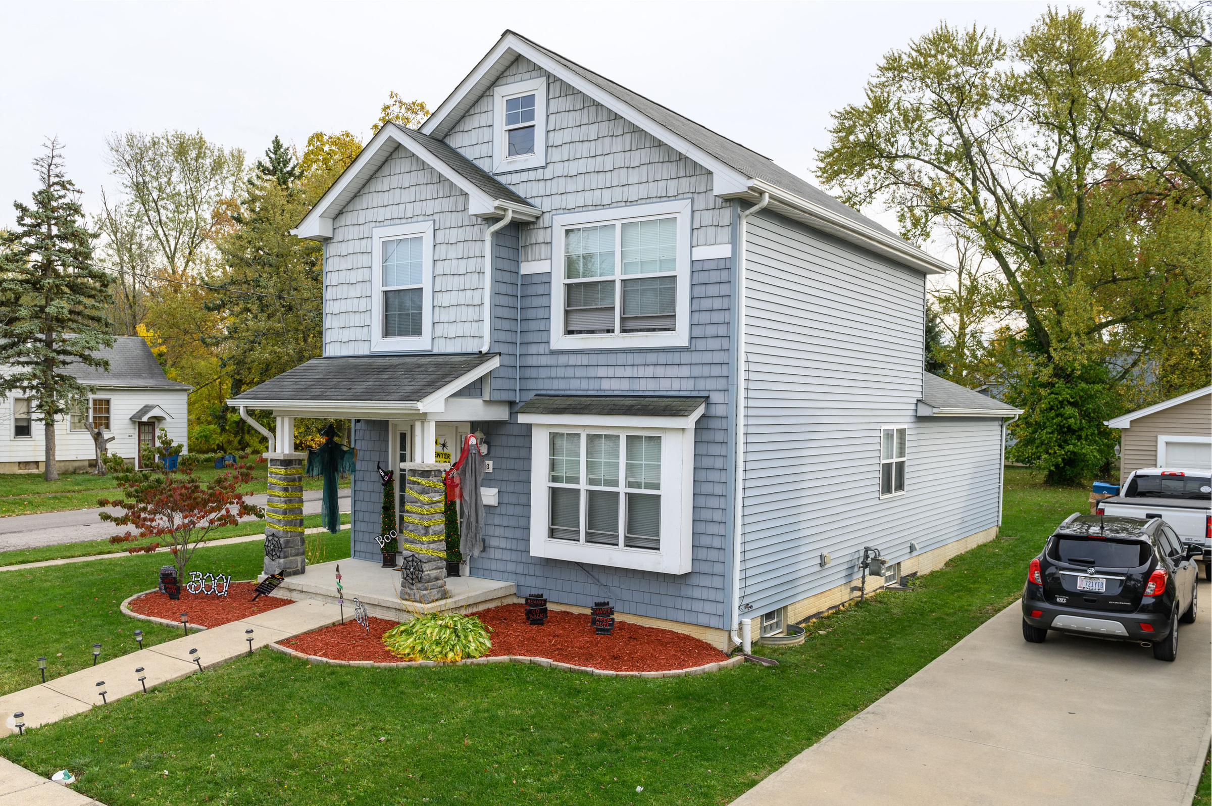 a blue house with a car parked in front of it