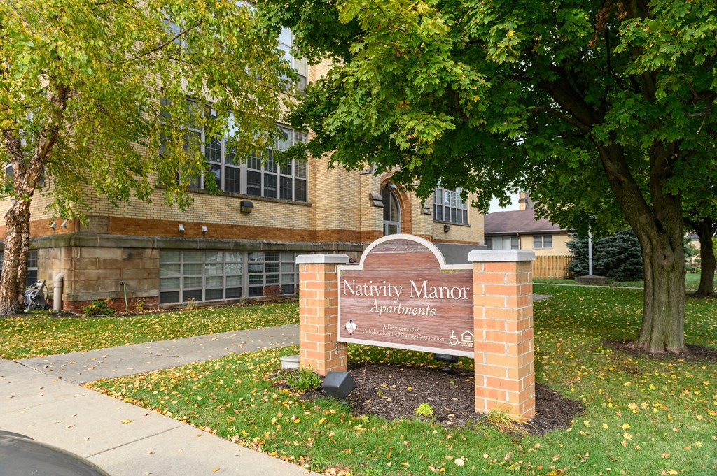 a sign in front of a building with a tree