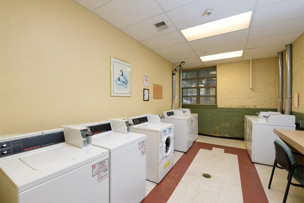 a room filled with washers and dryers in a laundromat