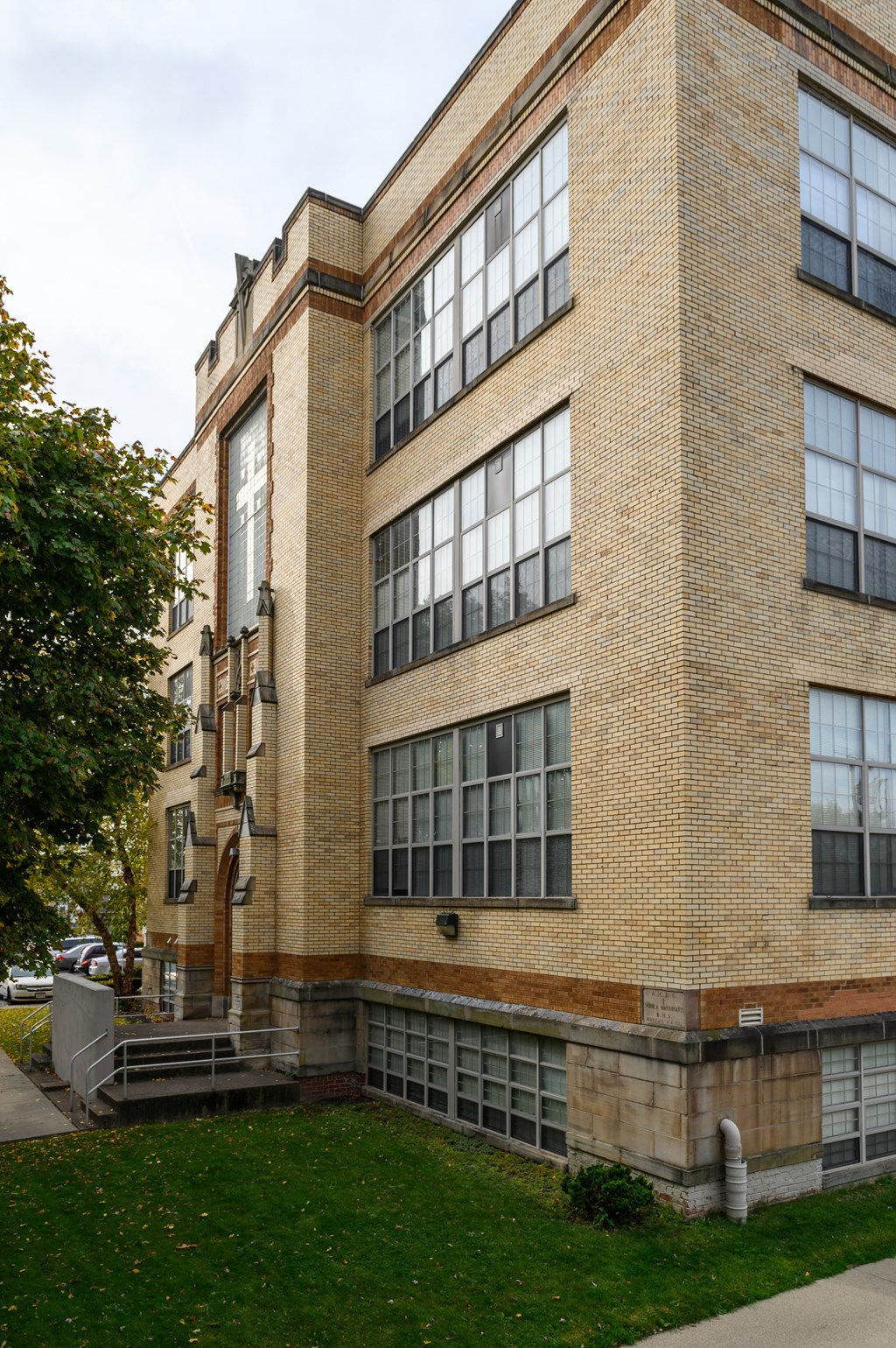 the side of a brick building with a green lawn