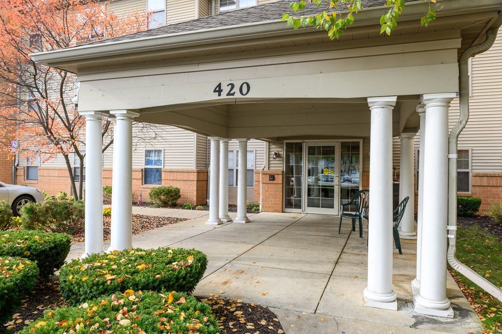 the front entrance of a building with pillars and a porch
