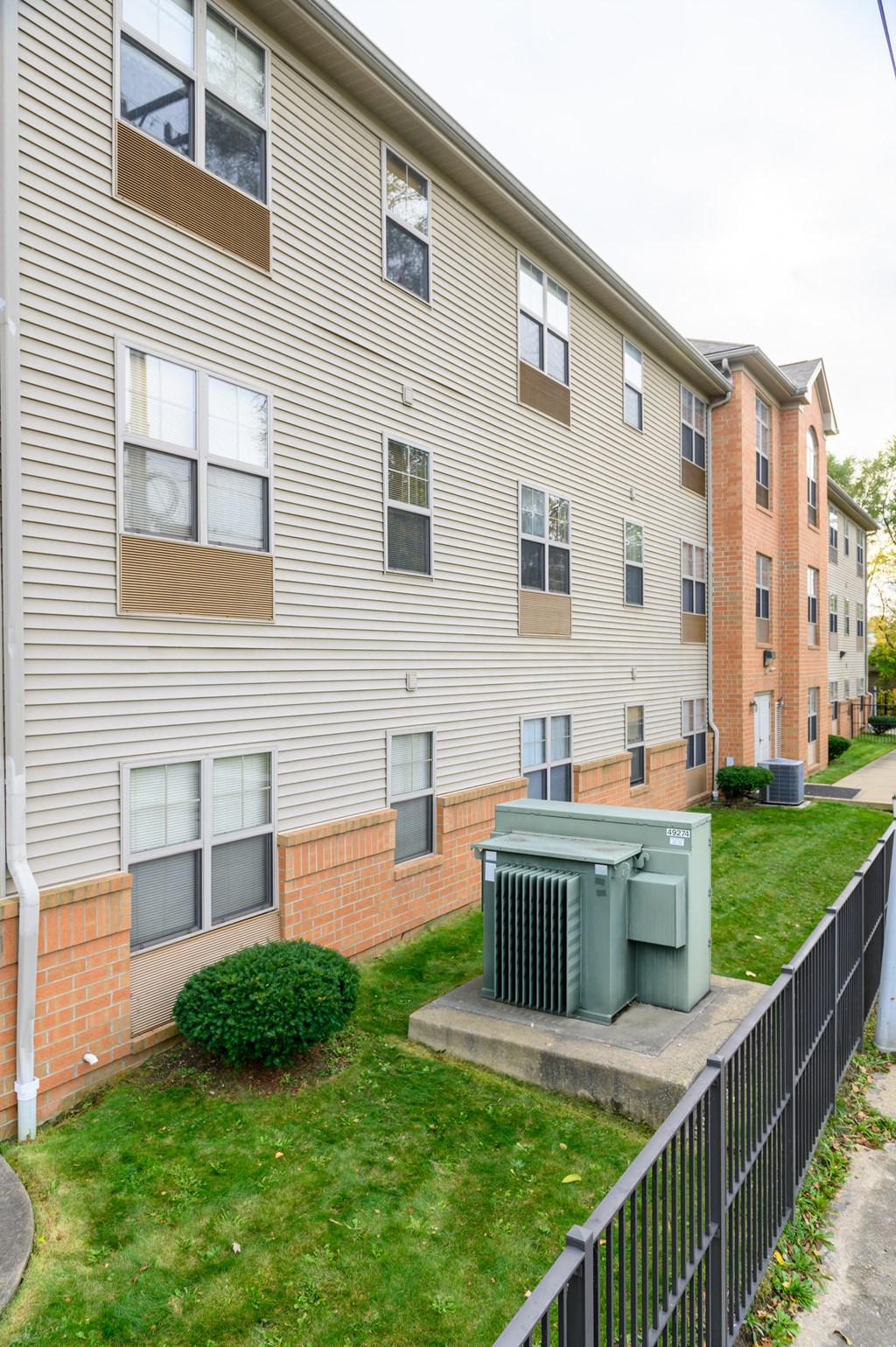 the outlook of an apartment building with a green yard and grass