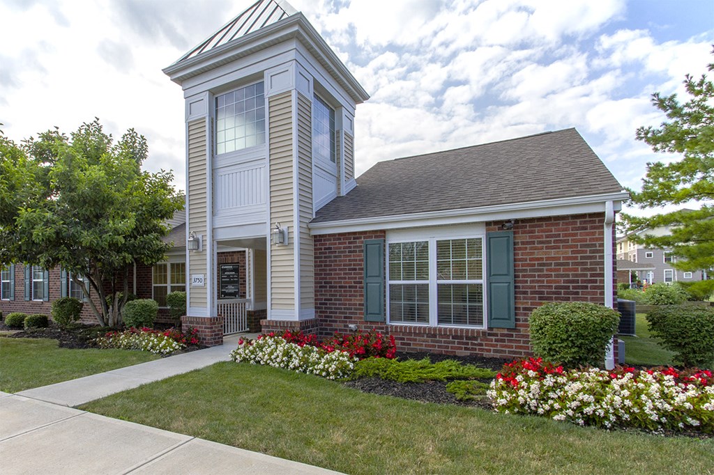 the front of a house with a walkway and flowers