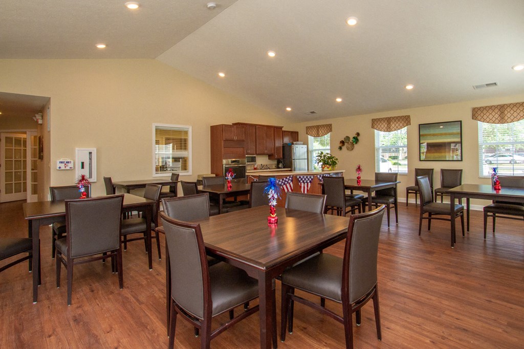 a dining room with tables and chairs and a kitchen