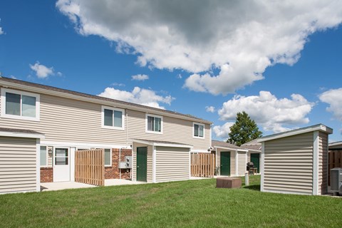 a row of manufactured homes with grass in front of them