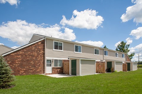 side view of a house with a brick wall and gray siding