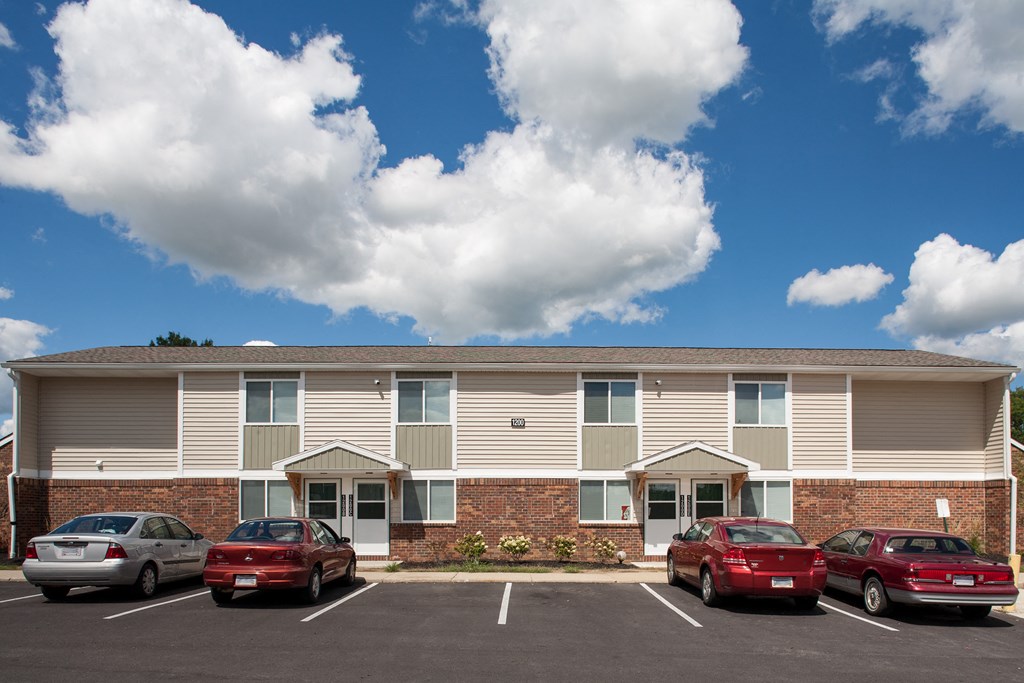 an apartment building with cars parked in front of it