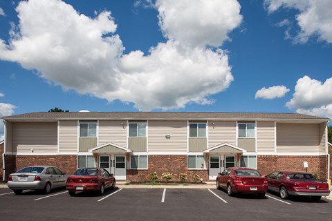 an apartment building with cars parked in front of it