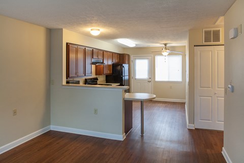 an empty apartment with a kitchen and a table