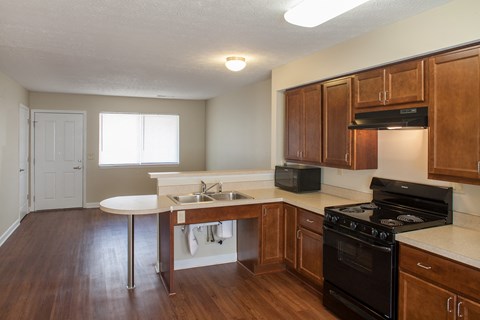 an empty kitchen with wood flooring and wooden cabinets