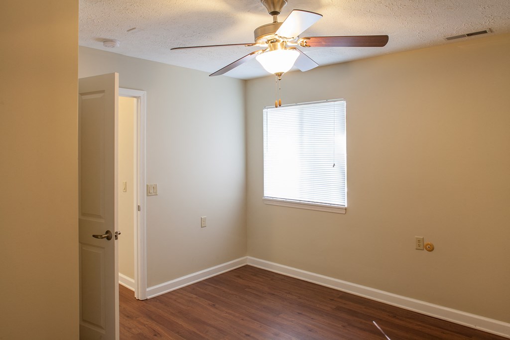 an empty room with a ceiling fan and a window