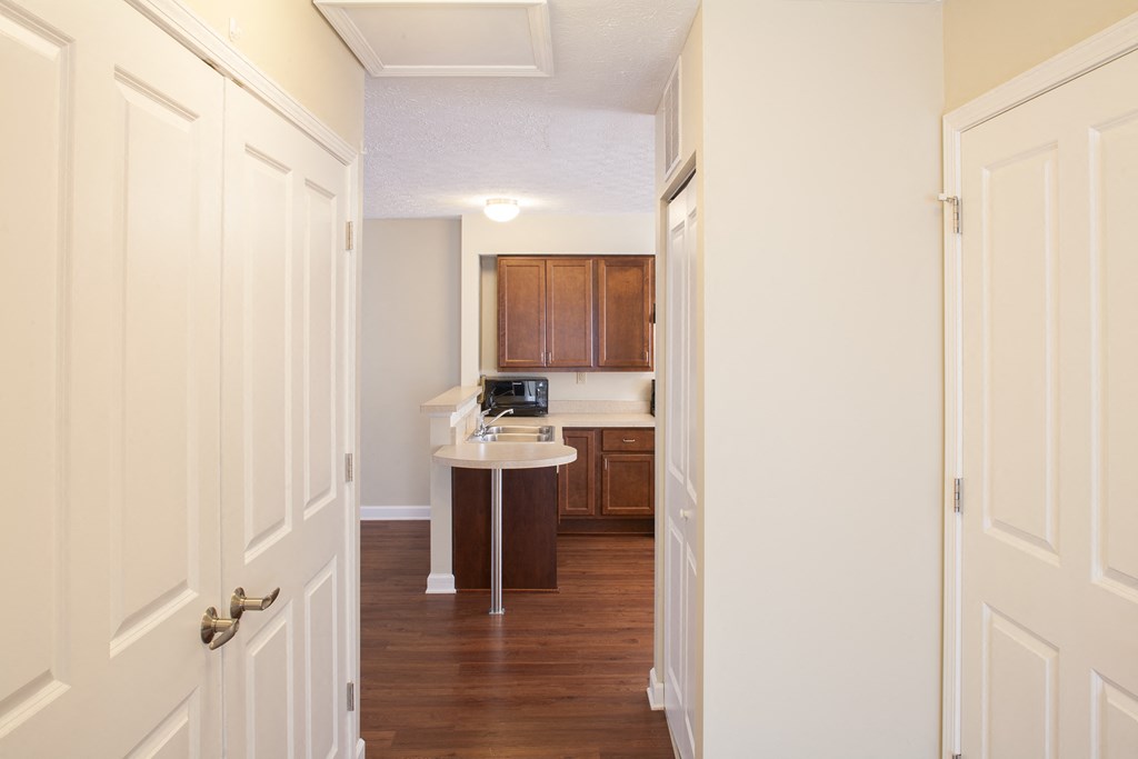 a view of a kitchen from a hallway with white doors