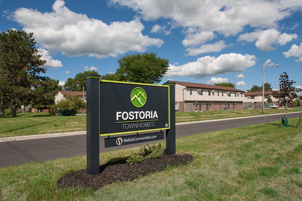 a sign for fossilia townhouses on the side of a road