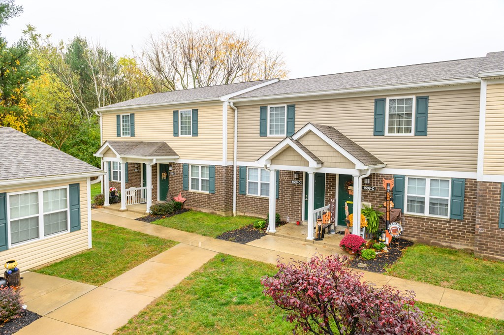 the front of a house with a walkway and grass